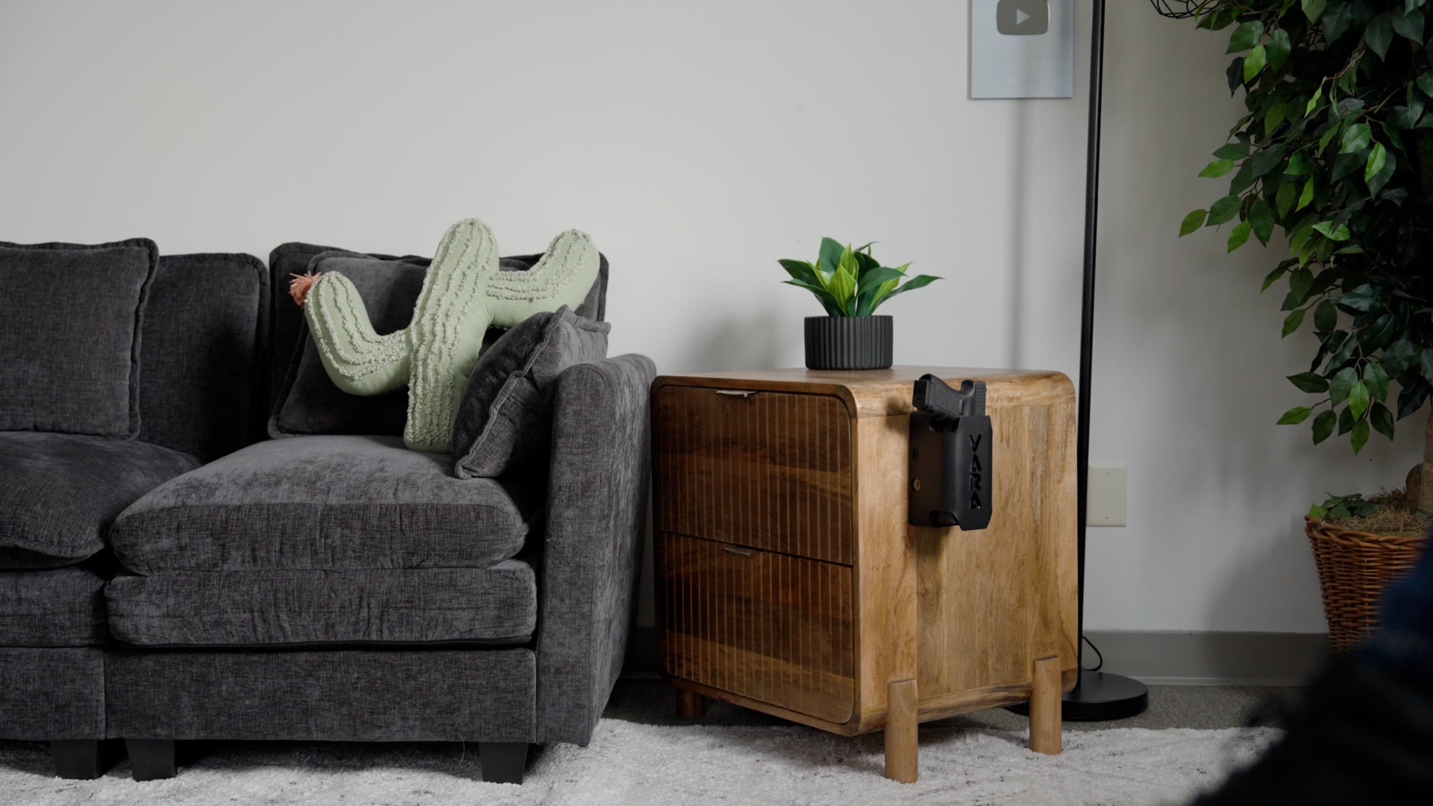 A living room with Reach Tactical mounted on the side of a wooden side table beside a sofa