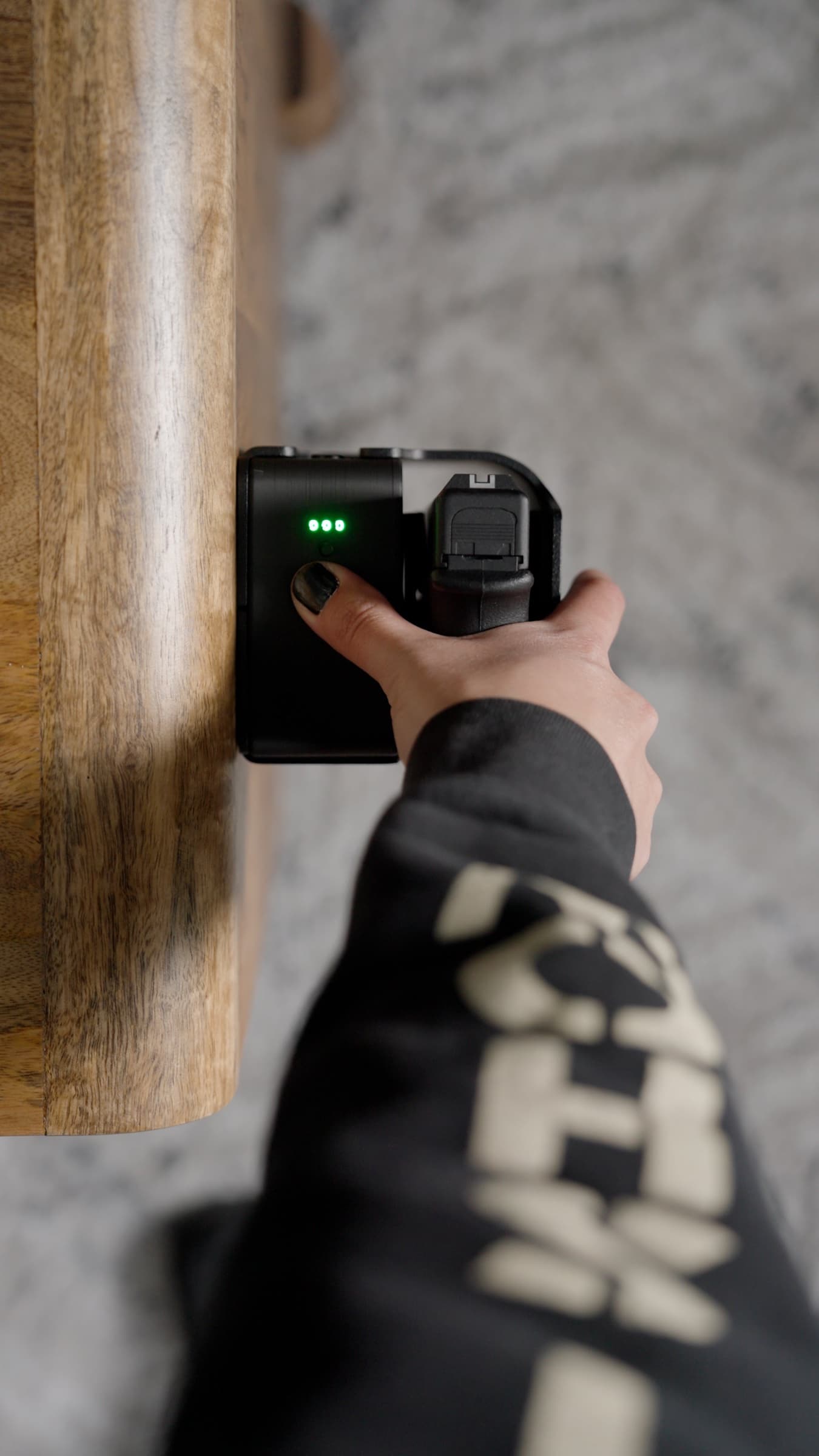 A finger on the Reach Tactical fingerprint sensor with the green status lights lit